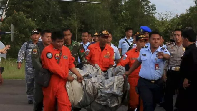 Members of the Search and Rescue Agency carry debris recovered from the sea presumed from missing Indonesia AirAsia flight QZ 8501 at Pangkalan Bun