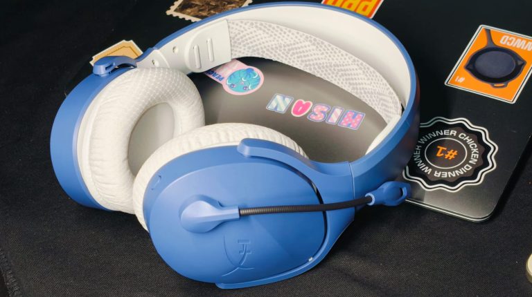 HyperX gaming headphones lying on top of a MacBook